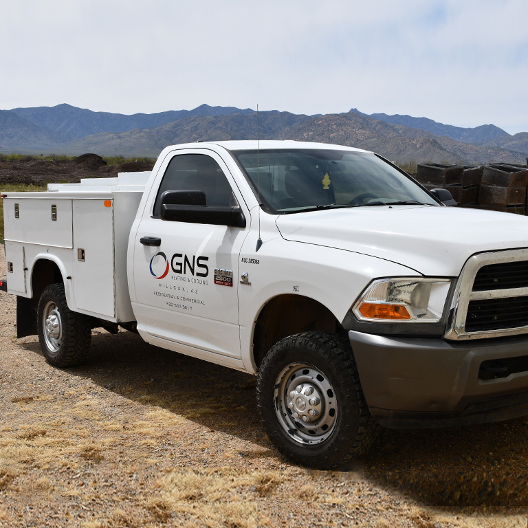 A GNS service truck parked in the desert with mountains behind it.